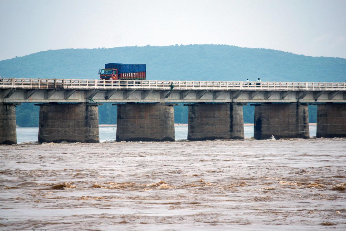 A truck passes over a bridge while floodwater of the Mahanadi river is released from the Hirakud Dam. A truck passes over a bridge while floodwater of the Mahanadi river is released from the Hirakud Dam.