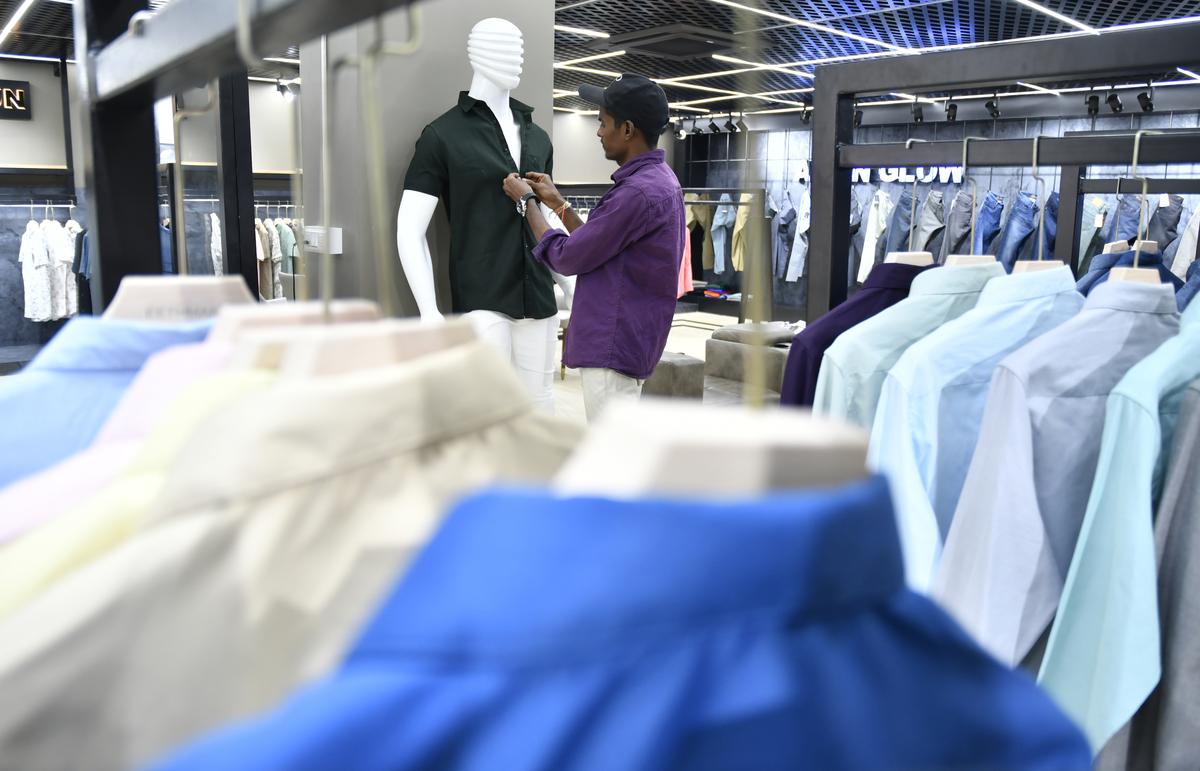 A worker arranges tailored shirts for sale  at an apparel manufacturing unit in Bengaluru.