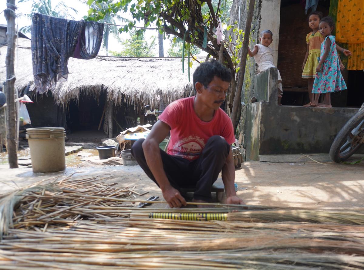 A Savara man preparing broom sticks with broom grass collected from Chelam Hill. 