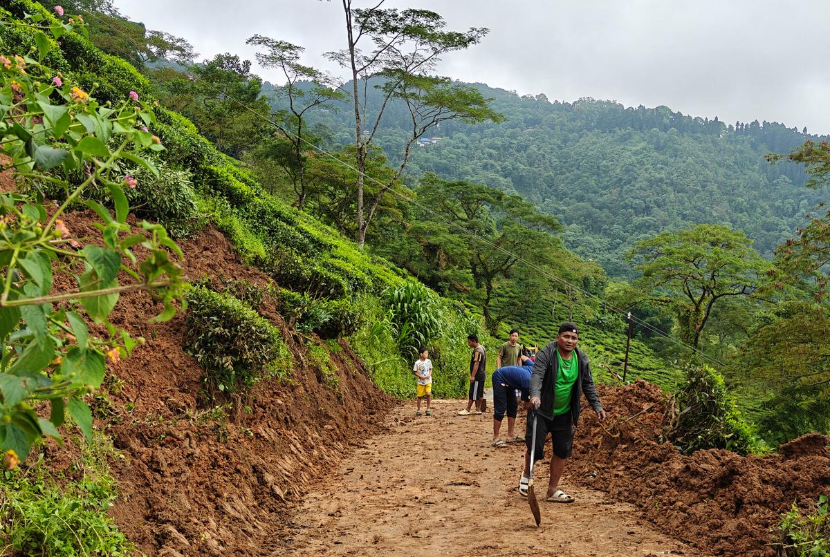 सुखियापोखरी के पास स्थानीय लोग अपने अवशेषों को खोजने और परिवहन के लिए रास्ता बनाने के लिए मलबा हटाने की कोशिश कर रहे हैं। 