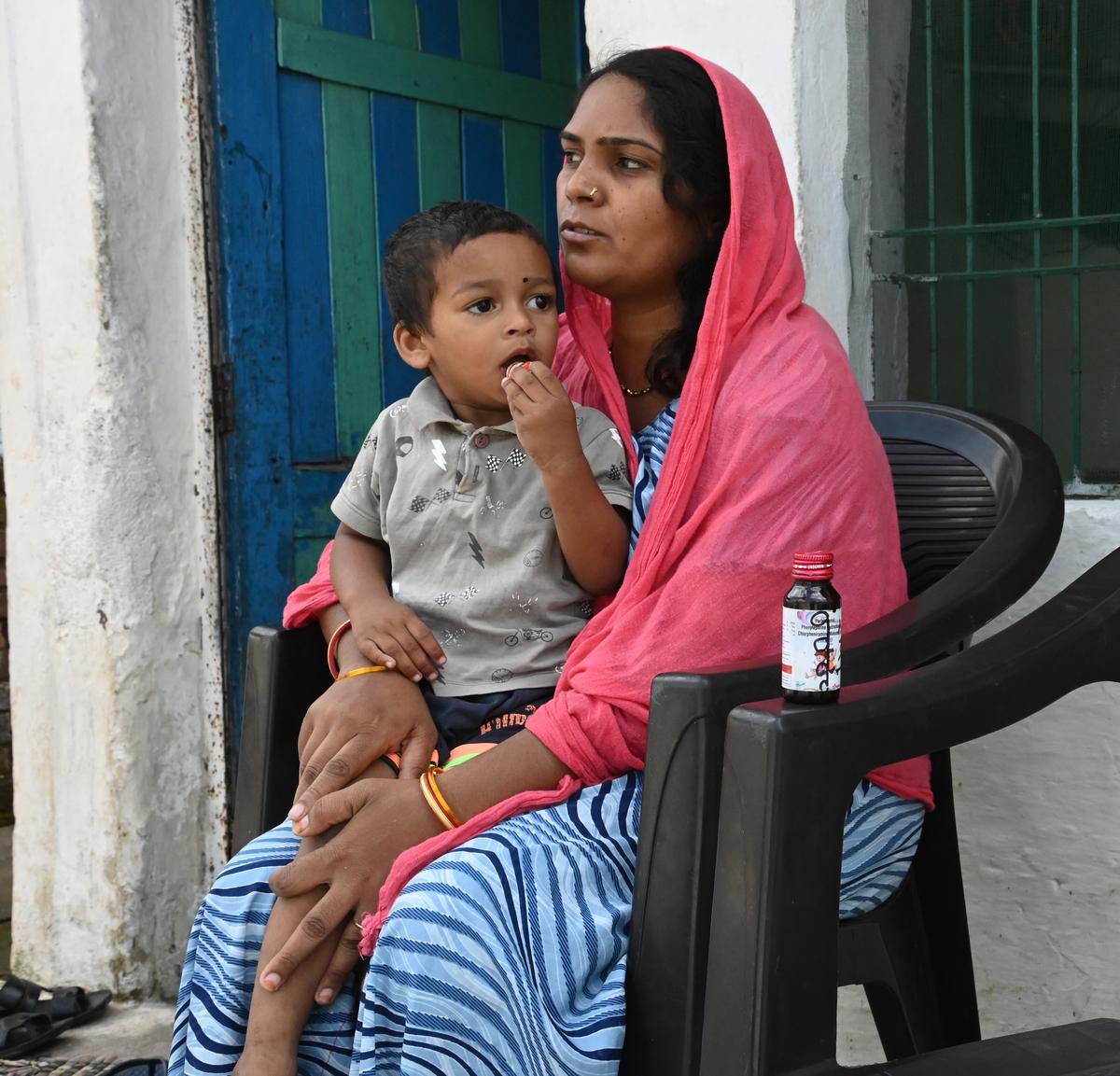 Afsana Khan sits with her son Yamaan. Khan’s 3-year-old son, Usaid, died due to kidney failure after drinking the cough syrup prescribed by a local doctor.
