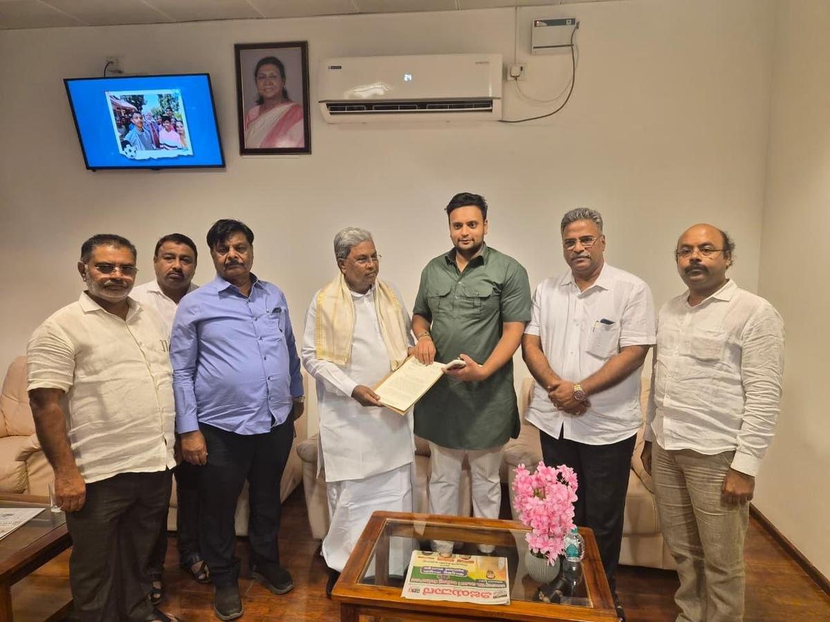 मुख्यमंत्री सिद्धारमैया (बीच में) मैसूर के सांसद यदुवीर कृष्णदत्त चामराजा वाडियार (दाएं से तीसरे) से एक ज्ञापन प्राप्त कर रहे हैं, जिन्होंने टी. नरसीपुरा में केएसआईसी फिलाचर फैक्ट्री की जमीन पर स्टेडियम बनाने की योजना को छोड़ने का आग्रह किया है।